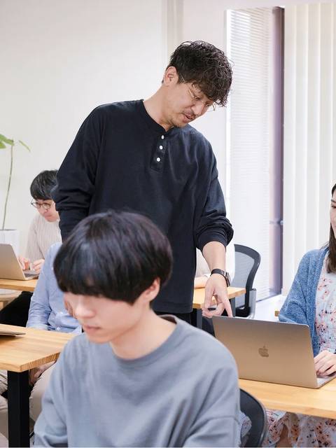 受講生の画面をのぞき込む講師