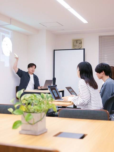 スクリーンの前で教える講師